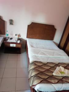 Dormitorio pequeño con cama y lavamanos en Hotel Indsurya, Dibrugarh en Dibrugarh