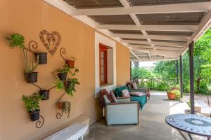 un patio con sofá y mesa con plantas en Bella de Karoo, en Calitzdorp