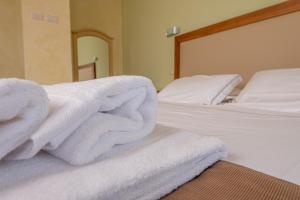a pile of towels sitting on top of a bed at Resort Capalbio in Capalbio