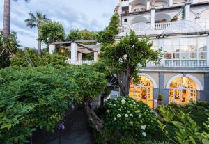 a large white building with trees in front of it at Grand Hotel Cocumella in Sant'Agnello