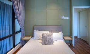 a bed in a room with a large window at Arte Mont Kiara by Cobnb in Kuala Lumpur