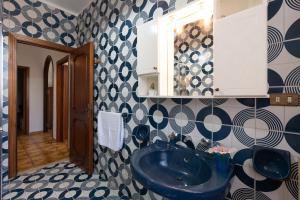 een badkamer met een blauwe wastafel en een spiegel bij Conchiglia al Mare in Trappeto