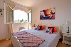 een slaapkamer met een bed met kussens erop bij Esprit du Sud Mascolo in Roquebrune-sur-Argens