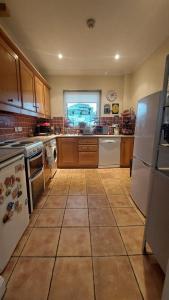 a large kitchen with white appliances and a window at Private Double Bedroom in front of the Galway Port - Guest House in Galway