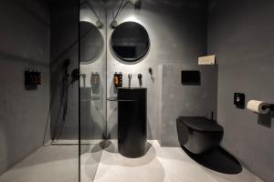 a bathroom with a black toilet and a mirror at Welkam in Poprad