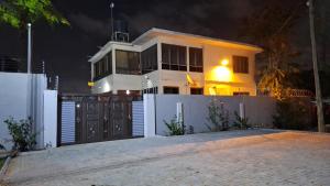 una casa blanca con una puerta y una valla en Cozy Luxury Hideouts in North Ridge, Accra, 1BDRM - 2BDRM, 15 mins from Airport, en Accra