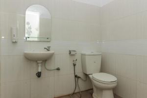 Un baño blanco con inodoro y lavabo. en RedDoorz @ Pantai Panjang Bengkulu, en Pekansaptu 10 fotos más
