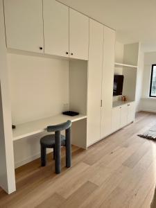 a room with a stool and a table and cabinets at Maison Olive in Torhout