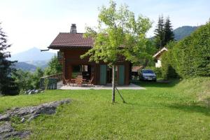 una pequeña casa con un árbol en el patio en Très belle vue pour un chalet de 200 m2, en Arâches-la-Frasse