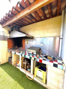 an outdoor kitchen with a stove and a grill at Villa Mars YourHostHelper in Narbonne