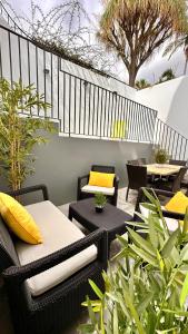 a patio with wicker chairs and tables and plants at Casa Branca Apartment in Funchal in Funchal