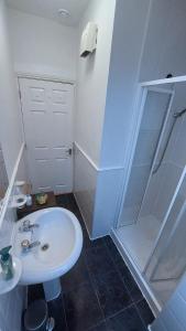 a white bathroom with a sink and a shower at Private Double Bedroom in front of the Galway Port - Guest House in Galway