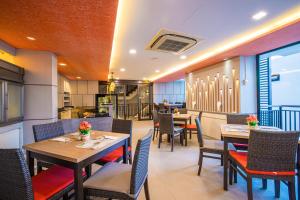 um restaurante com mesas e cadeiras e uma cozinha em Citrus Patong Hotel by Compass Hospitality em Praia de Patong