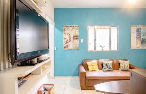 乌巴图巴Ubatuba Wild Surf Hostel的带沙发和大屏幕平面电视的客厅