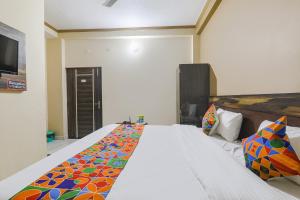 Un dormitorio con una cama con una manta de colores. en FabHotel SR, en Varanasi