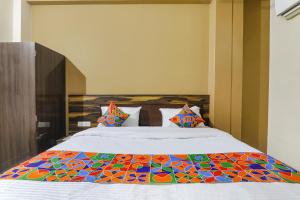 a bedroom with a bed with a colorful quilt on it at FabHotel SR in Varanasi
