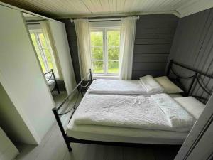a small bedroom with a bed and a window at Nordland House-Breathtaking View-Central Location in Sortland
