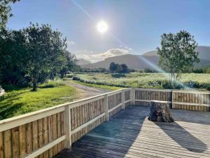 a wooden deck with a fence and a tree stump at Nordland House-Breathtaking View-Central Location in Sortland