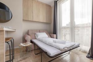 a bed in a room with a large window at Rent like home - Marszałkowska 28 in Warsaw