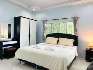 1 dormitorio con 1 cama con tocador y ventana en Xaiyong Resort - ไทรโยงรีสอร์ท, en Buriram