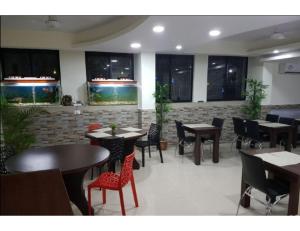 um restaurante com mesas e cadeiras num quarto em HOTEL MIDTOWN INN, Singrauli em Singrauli