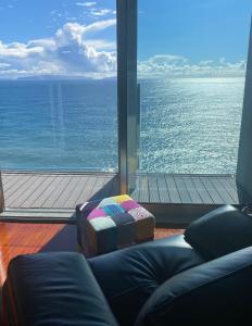 een woonkamer met een groot uitzicht op de oceaan bij Luxurious Penthouse Suite direct at sea in Caniço