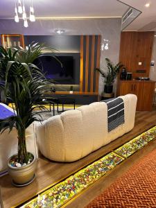a living room with a white couch and a plant at İstanbul Houses Sabiha Gökçen Airport Hotel in Istanbul