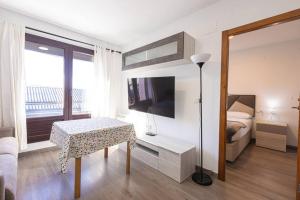 Zimmer mit einem Bett, einem Tisch und einem TV in der Unterkunft Terralta in Granada