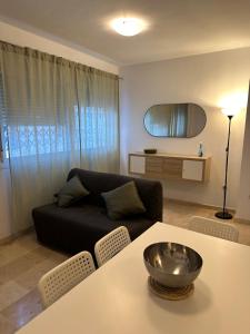 a living room with a black couch and a table at Mijas Playa Retreat in La Cala de Mijas