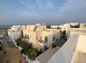 an aerial view of a white building with the ocean in the background at Muscat Seaside House in Muscat