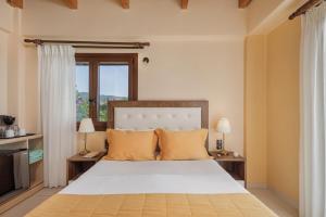 a bedroom with a large bed with orange pillows at Costa Smeralda in Sivota