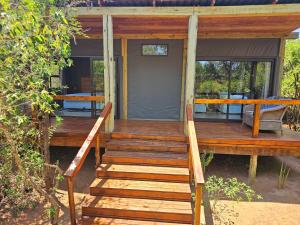 Kingfisher Creek Safari Lodge في هويدزبروت: درج خشبي يؤدي الى واجهة المنزل