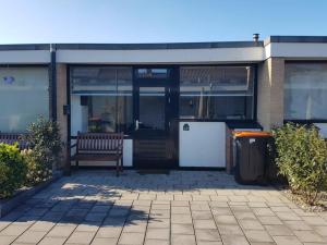 a bench sitting in front of a building at Zomerhuisje 18K - 1 km van het strand in Wijk aan Zee +4 photos