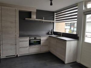 a kitchen with a sink and a stove at Zomerhuisje 18K - 1 km van het strand in Wijk aan Zee