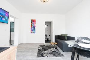 un soggiorno con un divano e un tavolo di MIRA StudioApartments NEU a Castrop-Rauxel