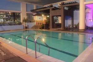 a large swimming pool in a hotel at night at Prince Plaza II Condotel in Manila