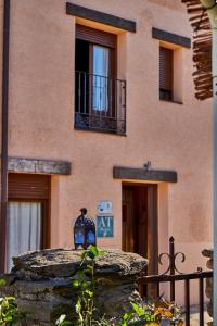 una bottiglia blu seduta su un muro di pietra di fronte a un edificio di Alojamiento Rural Fuente del Arca (Prádena del Rincón) a Prádena del Rincón