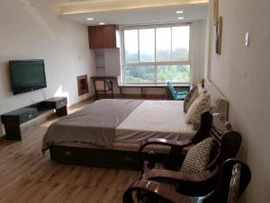 1 dormitorio con 1 cama grande y TV en Richhariya Nature's Retreat Homes en Jhānsi