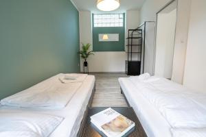2 camas en una habitación con un libro en el suelo en MIRA StudioApartments NEU, en Castrop-Rauxel
