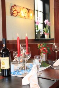 a table with a bottle of wine and wine glasses at Hotel Grüner Baum in Stollberg