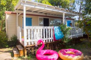 a small house with a pink flamingo and a float at Camping Village Le Capanne in Marina di Bibbona