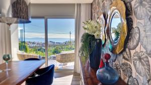 a dining room with a table with vases and a mirror at 24, The Townhouse by LovelyStay in Funchal