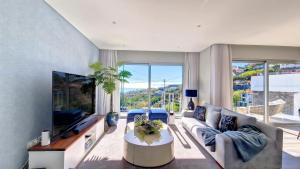 a living room with a couch and a tv at 24, The Townhouse by LovelyStay in Funchal