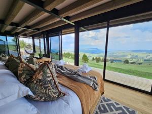 a bedroom with a bed with a view of the mountains at Eagle View on Beumont in Dullstroom