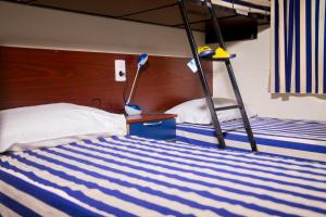 a bedroom with two bunk beds and a ladder at Camping Village Le Capanne in Marina di Bibbona