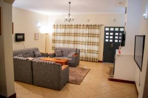 a living room with two couches and a table at The Luxurious Farm House in Kiambu