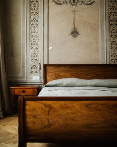 a bedroom with a wooden bed and a wall at Hotel Pod Różą in Kraków