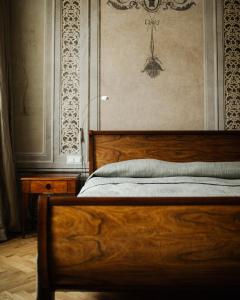 a bedroom with a wooden bed and a wall at Hotel Pod Różą in Krakow