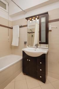 ein Badezimmer mit einem Waschbecken, einer Badewanne und einem Spiegel in der Unterkunft Costa Smeralda in Syvota