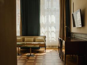 a living room with a couch and a table and a window at Hotel Pod Różą in Kraków